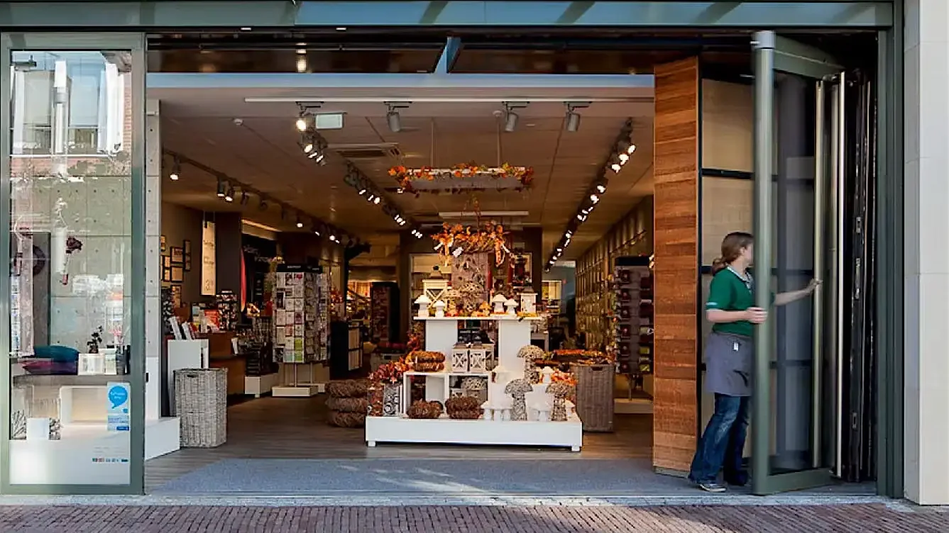 Devanture soignée d'une boutique de proximité avec vitrine décorée et entrée vitrée